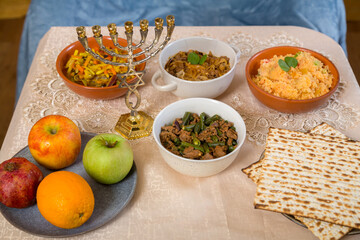 Shabbat set table with traditional food, fruits and menorah.