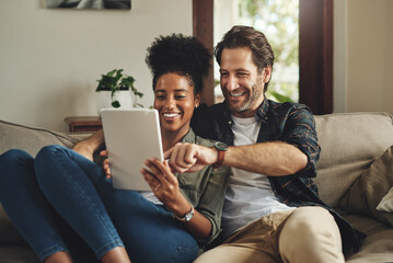 There are so many apps to choose from. a happy young couple using a digital tablet together while relaxing on a couch at home. - obrazy, fototapety, plakaty