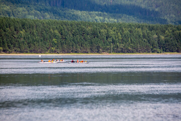 Obraz premium Tourists on boats float down the river in the wilderness in summer. Tourism, active recreation.