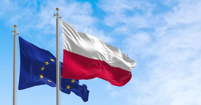 Seamless loop in slow motion of Poland and EU flags waving on a clear day