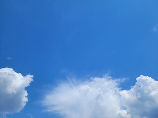 Deep blue sky with white clouds of various shapes. Clean air and the freshness of a new day. Beautiful view of clear sky, natural background. Copy space. Artificial noise and graininess. Soft focus.