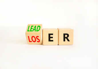Loser or leader symbol. Businessman turns wooden cubes and changes the word Loser to Leader. Beautiful white table white background. Business and loser or leader concept. Copy space.