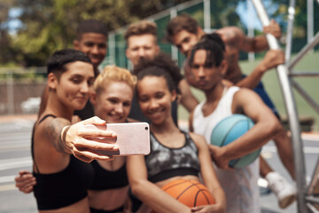 Sport can be a great way to make long lasting friendships. a group of sporty young people taking selfies together on a sports court.