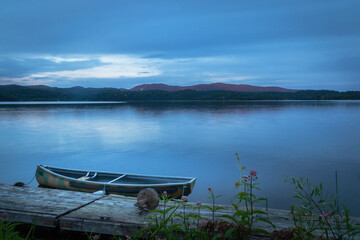 lake at the blue hour,  fishing boat on the shore by the deck