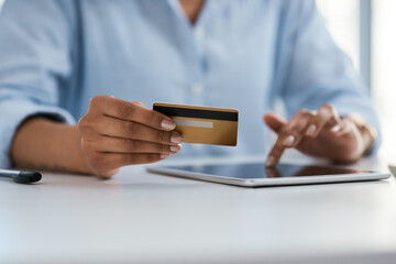 A quick and easy way to transfer money. Closeup shot of an unrecognisable businesswoman using a digital tablet and credit card in an office.