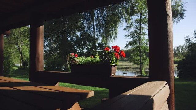 dolly shot of a flower pot on the edge of a fabulous log cabin patio