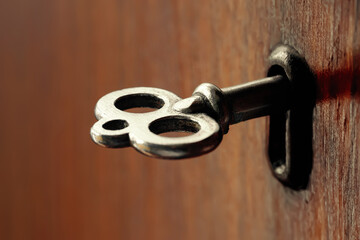 Old key. Antique key in the keyhole. Lock fittings. Shallow depth of field. Selective focus