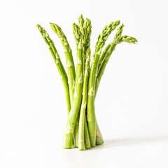 A bunch of fresh asparagus stands on a white background with a soft shadow