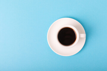 A cup of espresso coffee aroma on a blue background. Good morning concept. Top view with copy space for your text.
