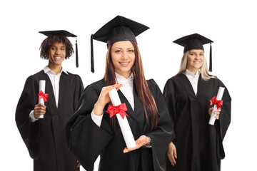 Three graduate students in black gowns holding university diplomas