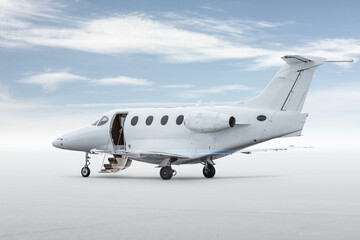 Modern white executive airplane with an opened gangway door isolated on bright background with sky