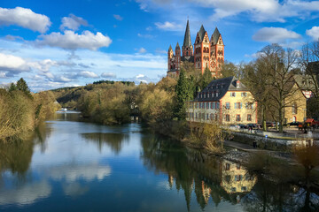Fototapeta na wymiar Scenic view of Limburg Cathedral, Germany and river Lahn against blue sky with clouds
