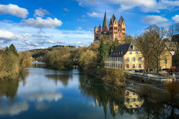 Obraz premium Scenic view of Limburg Cathedral, Germany and river Lahn against blue sky with clouds