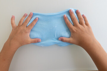 Overhead view of child hands playing with slime at table during play therapy