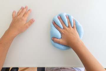 Child making a hand print in blue slime