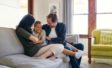 They know how to get her laughing. two affectionate young parents playfully tickling their daughter...