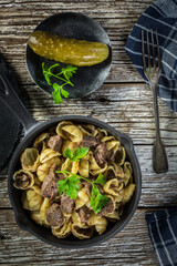 Italian pasta shells with beef sauce in cast iron pan.