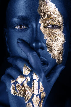 fashion portrait of a blue-skinned girl with gold make-up. Beauty face.