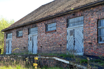 Stary opuszczony ceglany budynek fabryki z oknami i okiennicami. Tło przemysłowe. - obrazy, fototapety, plakaty