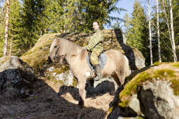 Obraz premium Icelandic horse and camouflaged woman in Finnish spring enviroment
