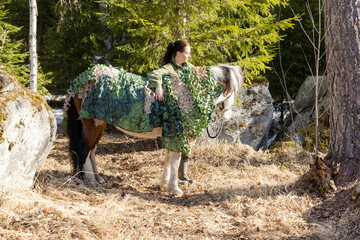 Camouflaged icelandic horse and woman in Finnish spring enviroment