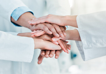 Improving the world through science in leaps and bounds. Closeup shot of a group of unrecognisable scientists joining their hands together in a huddle in a lab.