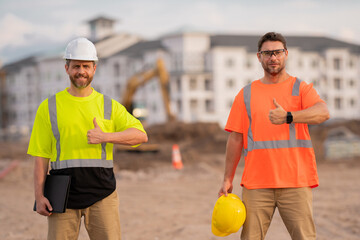 Two construction workers with hardhat helmet on construction site. Construction engineer workers in...