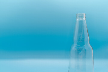 Half bottle of beer isolated on blue background selective focus, label design concept for bottle copy space