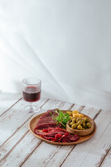 Beef jerky with spice. Red wine in a glass