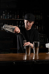 Bartender prepares classical Clover club alcoholic cocktail at the bar. Bartender mixes egg white, lemon, dry vermouth and gin to prepare the Clover club cocktail.