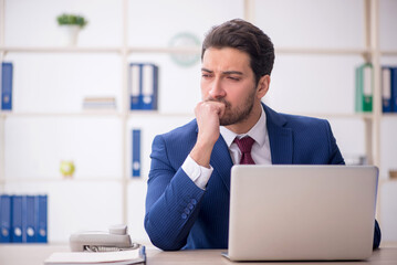 Young male employee and too much work in the office