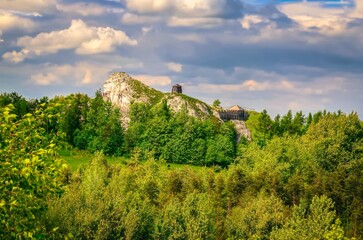 Fototapeta na wymiar Highland landscape in summer scenery. Man climbing on jurassic limestone rock, situated highland area of Jura in Poland.