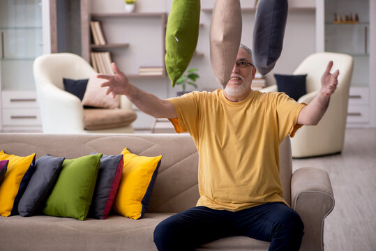 Old man with many pillows at home