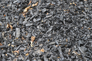 Ashes. Remains of burned wood. Bonfire turned off. Burnt tree trunks. Forest fire. Natural fuels. Texture.