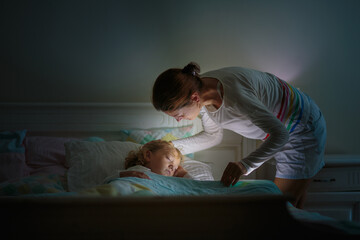 Child sleeping in dark bedroom. Little boy napping