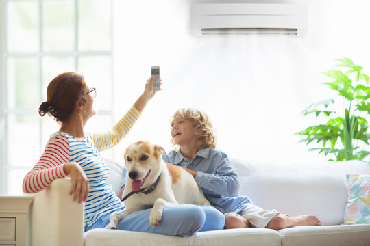 Mother and child with air conditioner remote