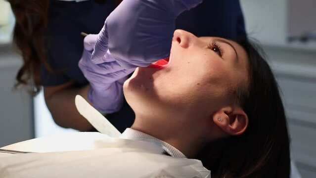 The dentist makes an injection in the oral cavity of the patient.
