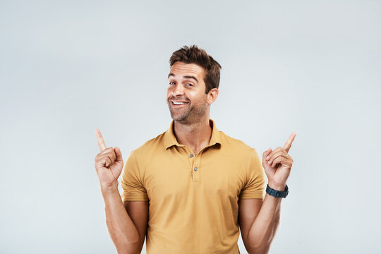 Pick me, Im your guy. Portrait of a young man with a excited facial expression while standing against a grey background.