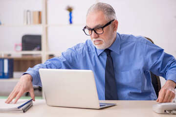 Old male employee working in the office