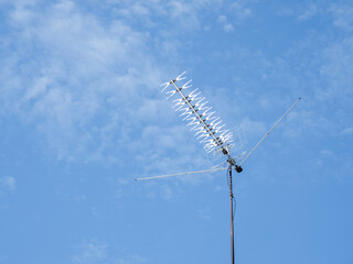 Obraz premium TV rooftop antenna on blue sky background. Industrial equipment used to receive internet signal, television connection and communication.