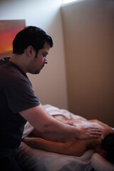 Photographs of massage and bodywork. Male therapist working on female client.  - 599054975