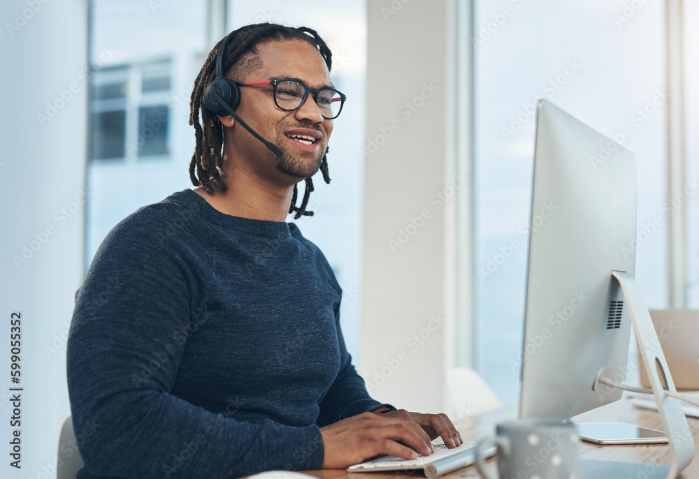 Aufkleber Logging calls and making big sales. a young businessman wearing a headset while working on a computer in an office.