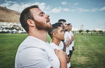 A great tradition. a team of confident young rugby players standing at attention singing their anthem outside on a field before a rugby match. - obrazy, fototapety, plakaty