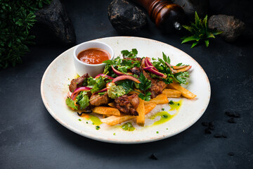 Fried pork fillet with French fries, onion, sauce and greens.