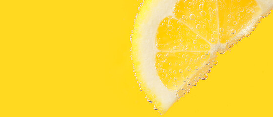 Lemon slice in water against yellow background with space for text, closeup