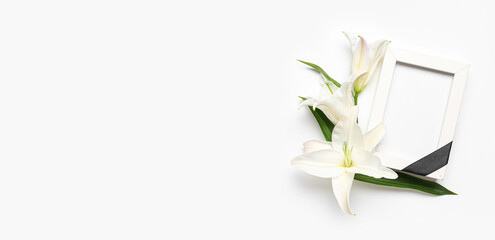 Blank funeral frame and lily flowers on white background with space for text - obrazy, fototapety, plakaty