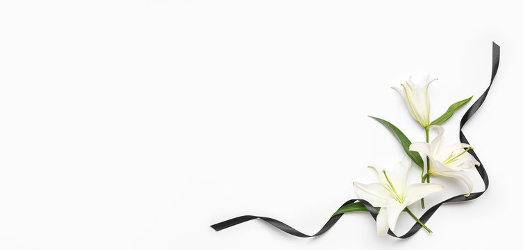 Beautiful lily flowers and black funeral ribbon on white background with space for text
