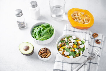 Roasted pumpkin avocado arugula goat cheese salad in a plate