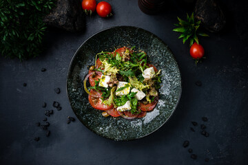 Lunch salad with Feta cheese, onion, lettuce, tomatoes, capers, arugula and spices.