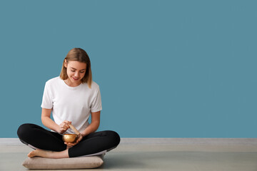 Fototapeta premium Young woman with Tibetan singing bowl at home